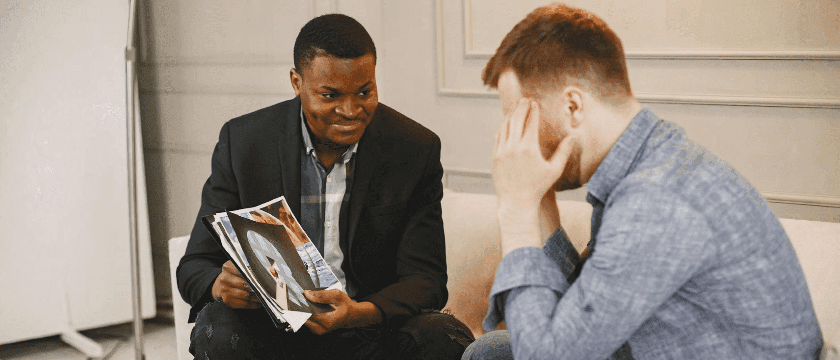 A Telleosis consultant showing printed work to a client during a meeting.
